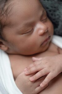 A close-up of a peaceful newborn baby sleeping wrapped in a soft blanket.